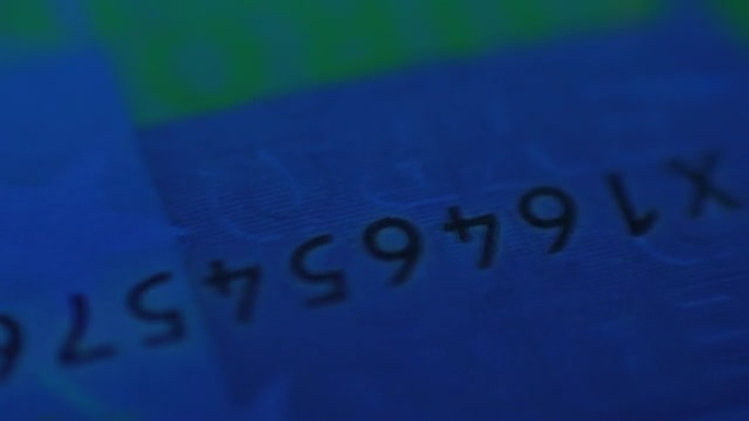 金融家银行家在紫外线下检查纸币。在显微镜和紫外线检测器下的钞票的极端特写视图。放大镜下的欧元钞票。