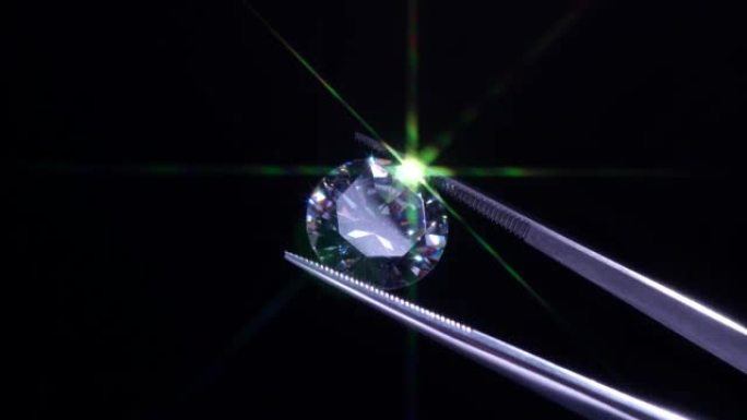 镊子中的钻石选择性聚焦，检查和分析明亮切割的水晶抛光质量。珠宝专业手工制作工作室。宏观拍摄，浅层深度