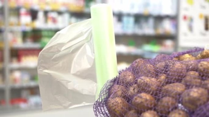 在塑料袋背景上的网格中的生土豆，在超市出售。零售商店概念。高质量全高清镜头