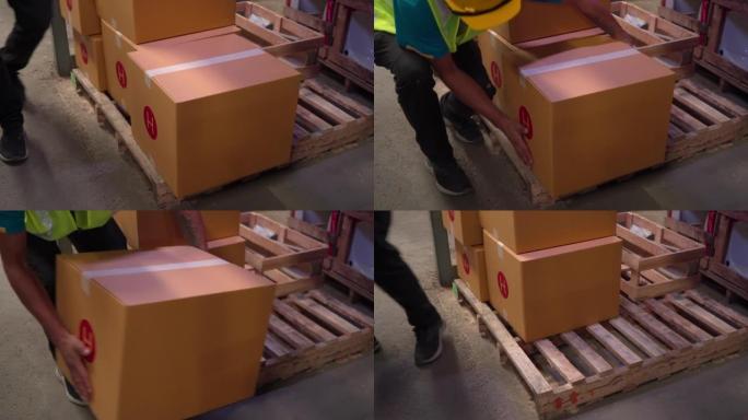 4K，近距离的手从木板上抬起纸板箱，准备进行库存检查，工作人员将产品在仓库中运送到物流公司，为客户运