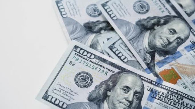 俯视一张美国钞票掉在一张白色桌子上。数钱——俯视图。