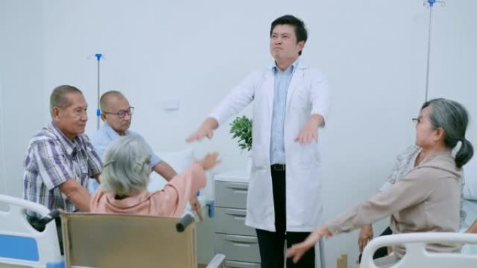 一群老年女性和男性正在训练肌肉发达，他们与有魅力的男性医生在家里伸展双手。聪明的亚洲理疗师正在疗养院