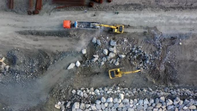 两台挖掘机从卡车上卸下石头