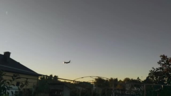 散焦视频。飞机在日落天空的乡下飞行。