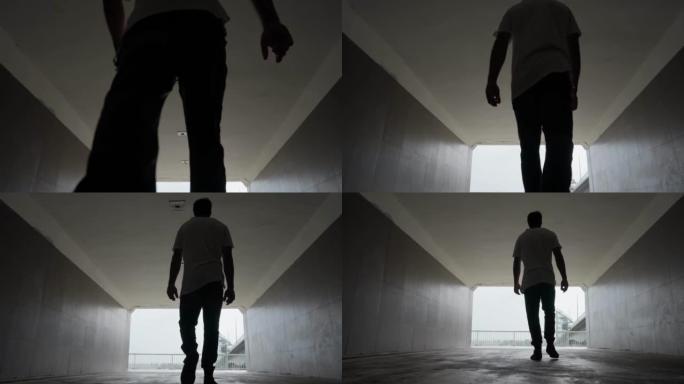 人类从黑暗中走过一条地下通道进入光明。慢动作