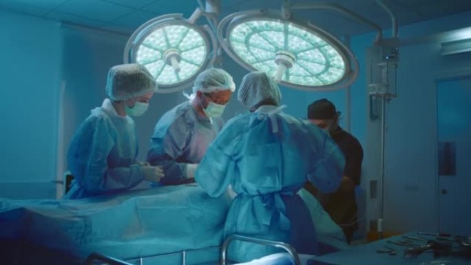 手术室里的四个人正在讨论并为患者进行胃部手术