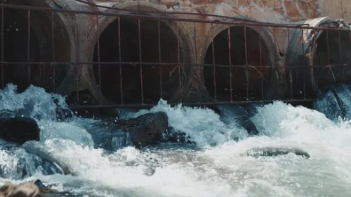 脏水从混凝土管道偷偷流入河中。对自然的生物危害。