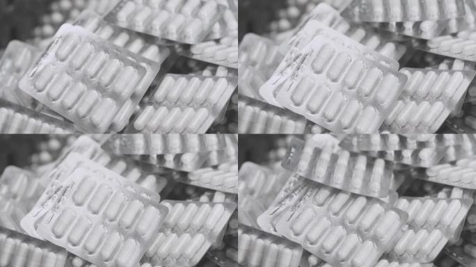 在慢动作胶囊水泡中掉落的4k特写镜头。药物成分医疗产品颗粒胶囊。白色背景上有泡罩包装的药丸。医疗保健