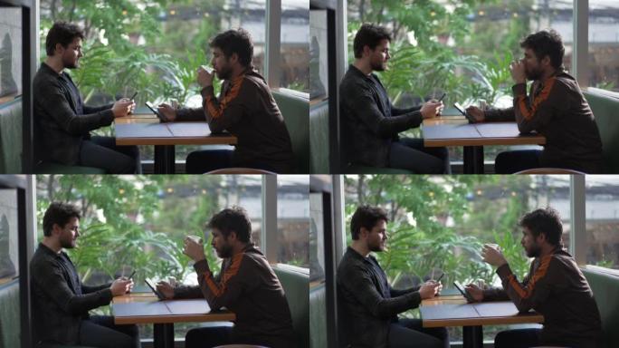 两个男人坐在咖啡店里看着手机
各自处于自己的技术泡沫中。人们在咖啡馆盯着智能手机
