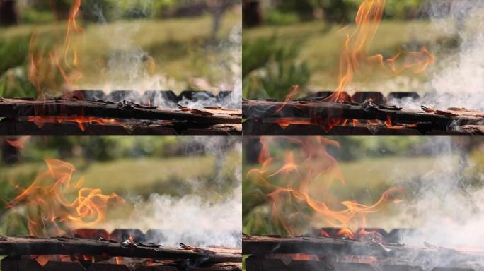 火焰烧木棍火焰烧令人惊叹的红色舌头。烧烤树林，在金属烤架中燃烧的灰煤，为户外烧烤做准备。燃烧的木柴、