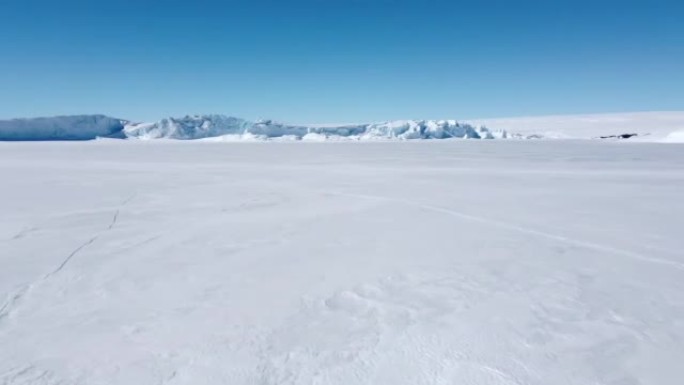 积雪覆盖的南极地表鸟瞰图飞行。