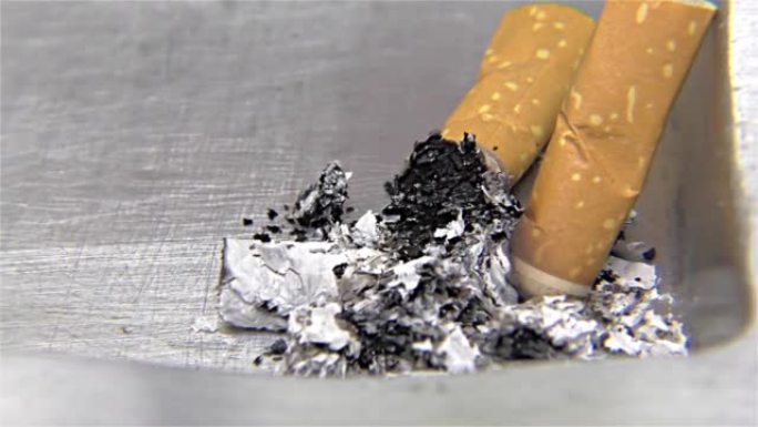 烟灰缸上的香烟燃烧-特写，细节，微距
