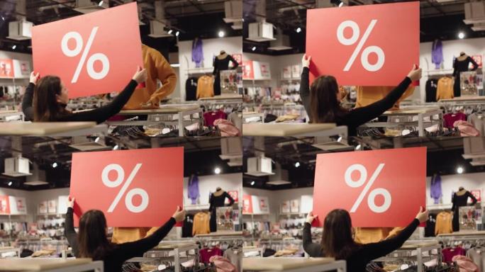 女卖家安装模特服装商店的红色折扣标签销售手