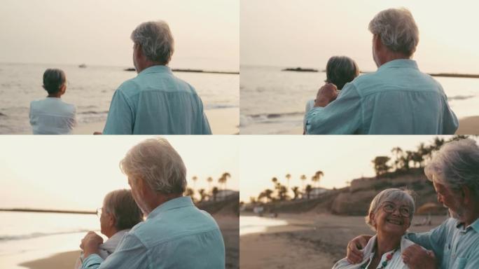 一位老人在海滩上抱着妻子，穿着毛衣一起享受寒冷的假期。相爱的人，一起感到自由