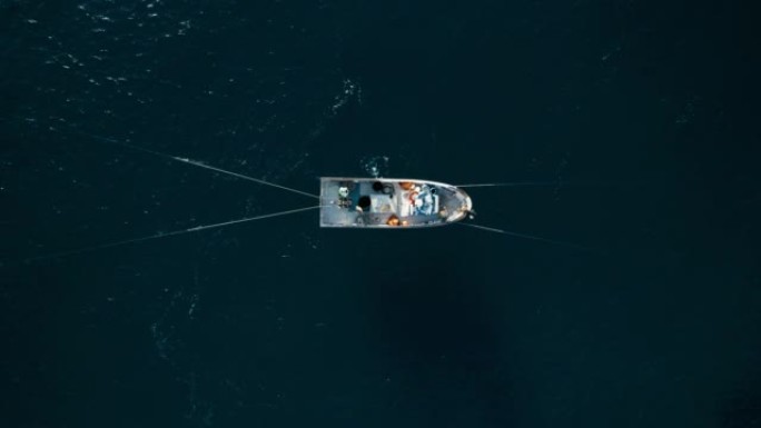 渔民用小船在海洋中拖网捕捞沙丁鱼和海鱼