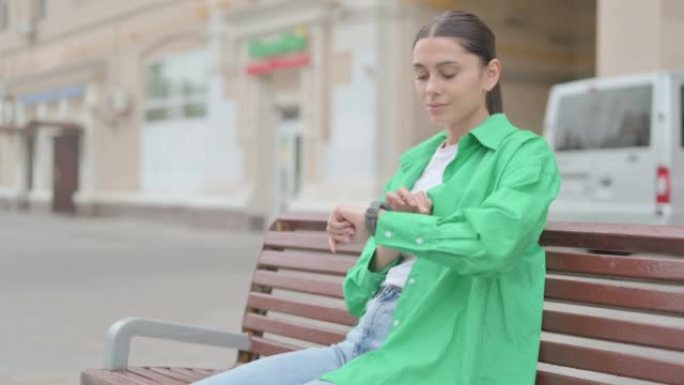 Hispanic Woman Using Smart watch while Sitting on 