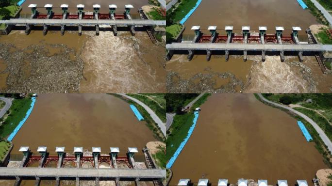 从混凝土坝排水通道释放的水的鸟瞰图是雨季溢水的一种方式。从泰国北部农村的水坝流出的浑浊的棕色森林水的