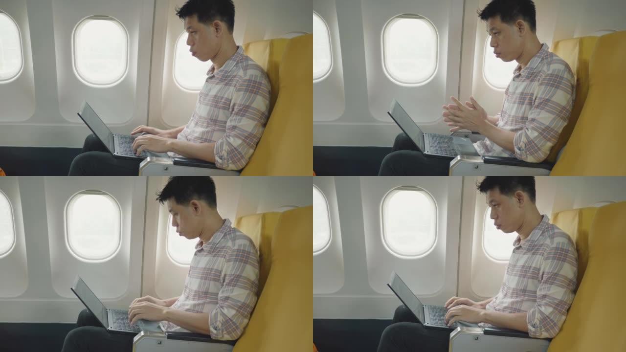 乘飞机旅行时使用笔记本电脑和手机的东南亚商务旅客。