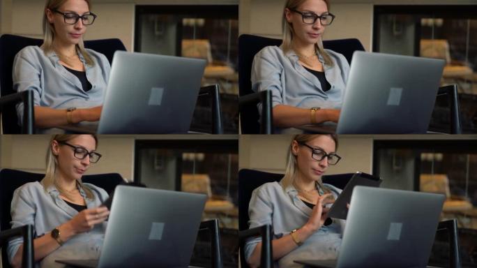 高加索女性远程工作者通过蓝牙连接在连接到互联网的数字平板电脑和笔记本电脑上共享媒体文件，用于浏览互联
