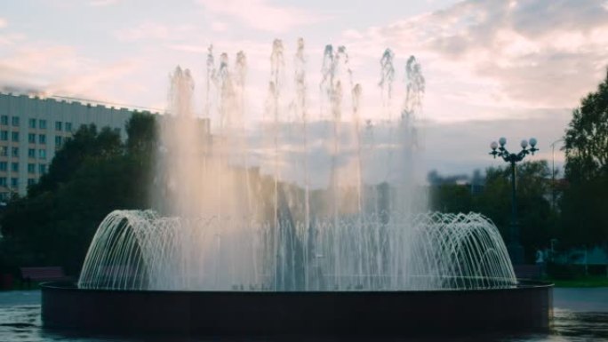 傍晚夏日城市的喷泉中升起水柱