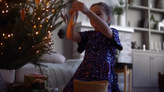 快乐的女孩用玩具装饰圣诞树。树下有很多礼品盒