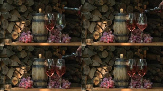 将玫瑰酒倒入装有粉红色葡萄的木制桌子上的葡萄园的玻璃杯中。侍酒师将甜点酒倒入玻璃杯中。酒厂。品酒。填