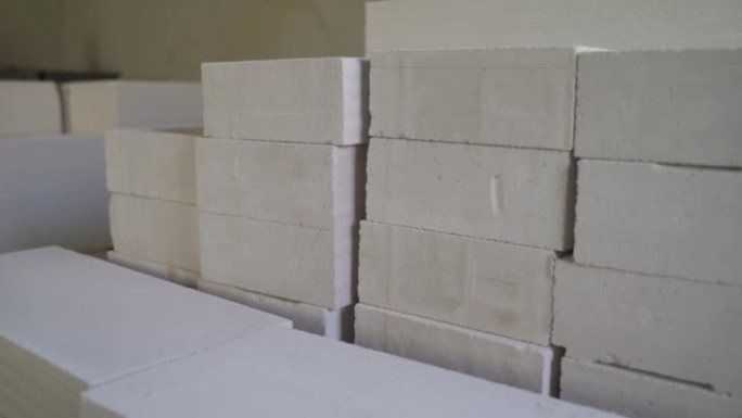 用于隔墙的薄白色积木。分区气体硅酸盐块放置在角落。施工现场的石膏砌块。用于建造隔板的大量轻质建筑材料
