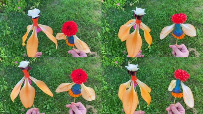 儿童手握由花瓣和橡皮泥制成的玩偶在棍子上的特写镜头。夏天孩子创造力的想法。