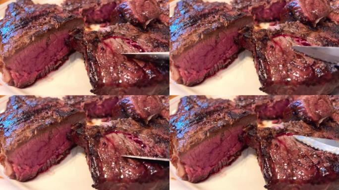 盘子上有带血的肉它是用刀在烧烤架上炸的牛肉，摸摸它，肉红，非常开胃和多汁，它让你想吃它，肉切成薄片，