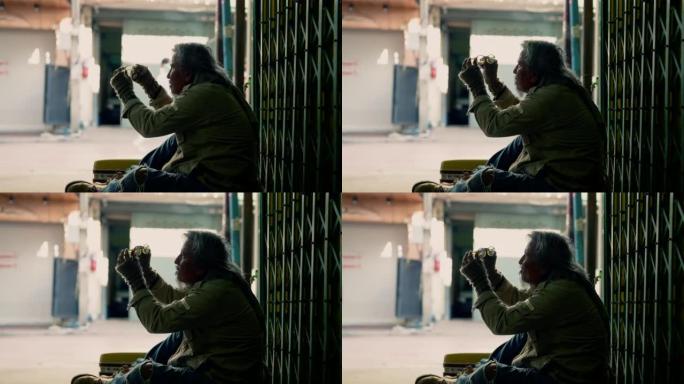 乞丐无家可归的老人心烦意乱，坐在人行道上没钱，失业的可怜的老人试图修理他的破眼镜，社会经济问题人权利