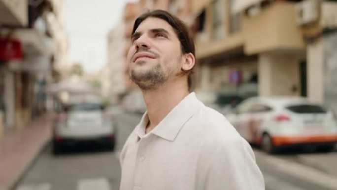 年轻的西班牙裔男子在街上表情轻松地望着天空