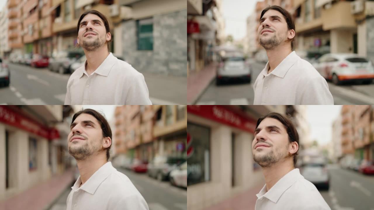 年轻的西班牙裔男子在街上表情轻松地望着天空