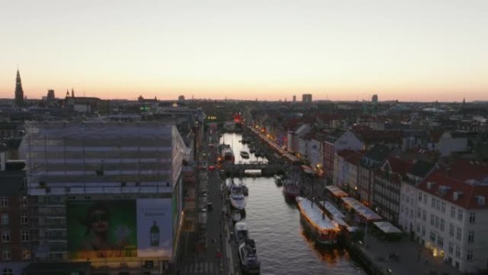 Nyhavn的空中上升镜头。有水渠和长廊的著名街道。水面反射着黄昏的天空。丹麦哥本哈根
