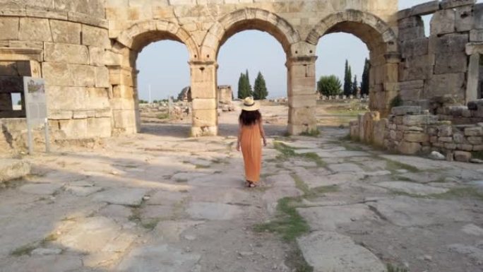 在德尼兹利的Pamukkale，游客女孩正走向希拉波利斯古城遗址的Frontinus Gate