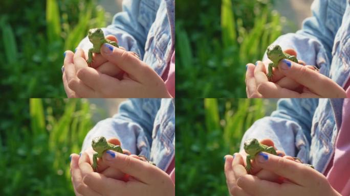 一个小女孩手里拿着一只绿色的小蜥蜴。一个不寻常的宠物。