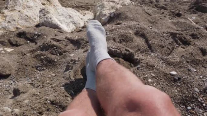 一个穿着灰色袜子晒日光浴的陌生人的腿。