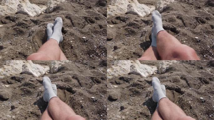 一个穿着灰色袜子晒日光浴的陌生人的腿。