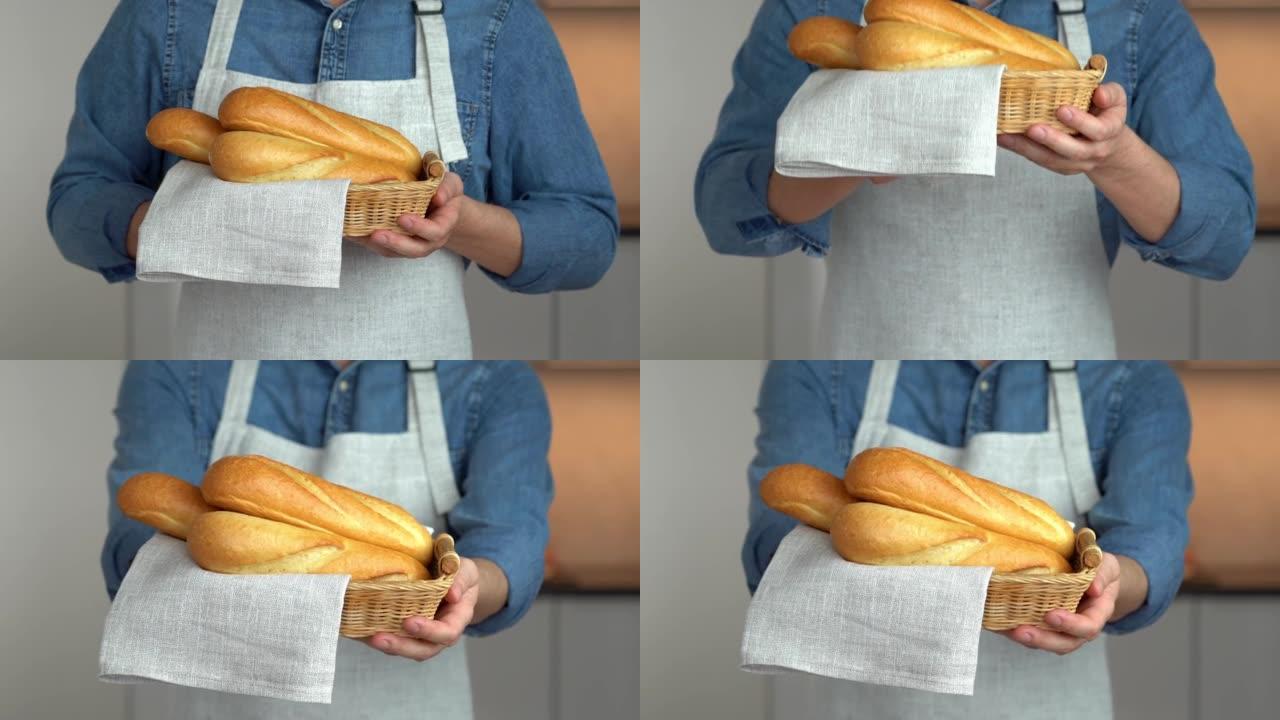 面包师手里拿着柳条篮和新鲜出炉的面包。法式长棍面包。面包店。食物
