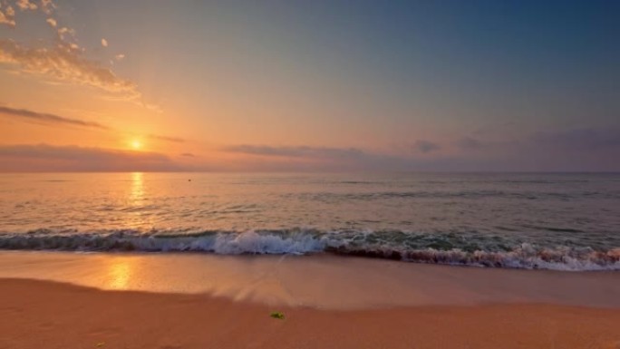 海洋海滩日出，彩色天空云和海浪上的太阳光线，4k视频景观。沙子上的脚印。