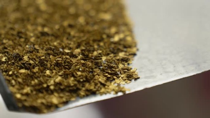 从托盘上掉下来的矿山挖出的黄金贵金属碎片的特写