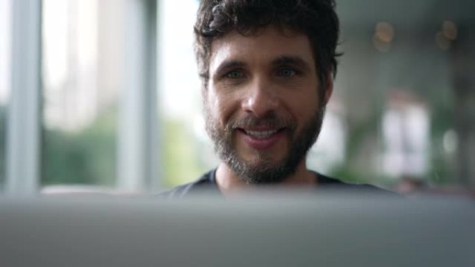 快乐男人特写脸看着电脑屏幕。浏览网上喜欢内容的人。盯着笔记本电脑的家伙
