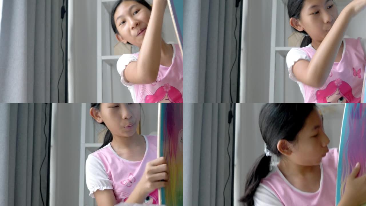 亚洲女孩拆箱新滑板是从家里网上购物购买的，生活方式概念。