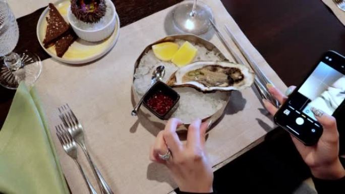 灰色碗里的牡蛎，深色桌子上放着冰。健康海鲜