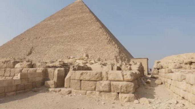 在非洲阳光明媚的埃及吉萨金字塔建筑群的胡夫金字塔前的沙块-倾斜视图