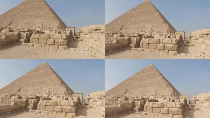 在非洲阳光明媚的埃及吉萨金字塔建筑群的胡夫金字塔前的沙块-倾斜视图