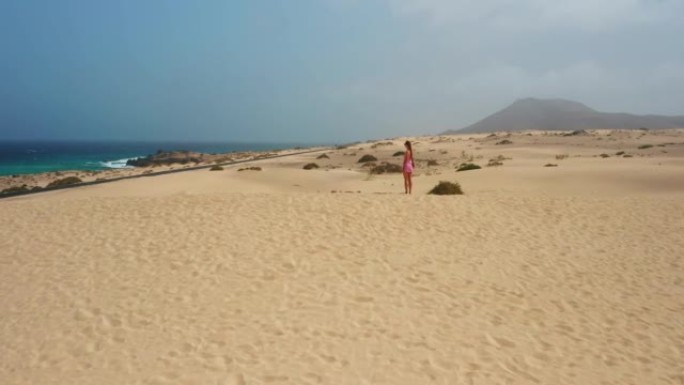 Eoung女人喜欢放松。海边的沙丘。暑假，科拉雷霍的野生沙漠自然。大西洋沿岸，蓝色的海水。感受自由。