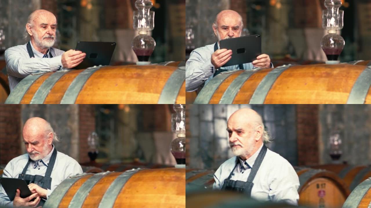 酿酒师使用触摸板平板电脑检查酒桶中的葡萄酒陈酿数据