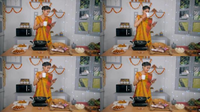 节日期间，一名印度妇女在装饰精美的厨房里穿着五颜六色的纱丽