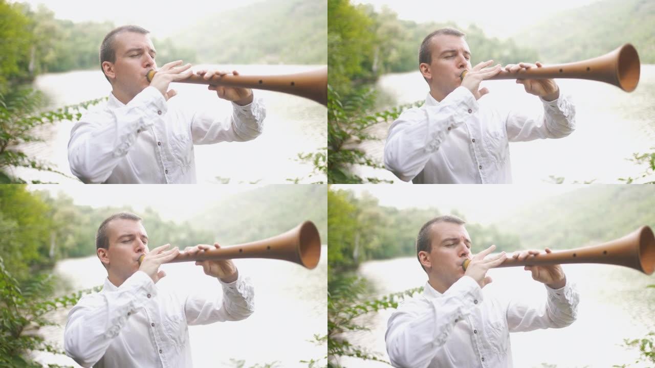 男性民间音乐家在森林中演奏响亮的Zurna乐器时闭上眼睛