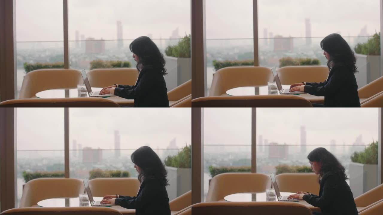 女商人用笔记本电脑在办公桌前工作。
